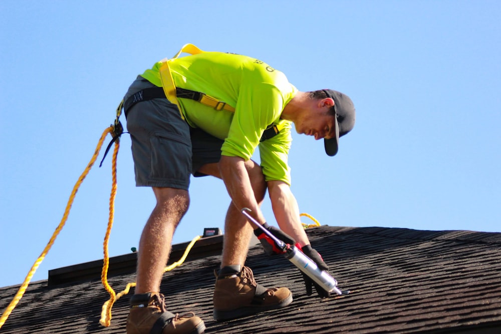 A roofing professional examining shingles up close on a residential roof.