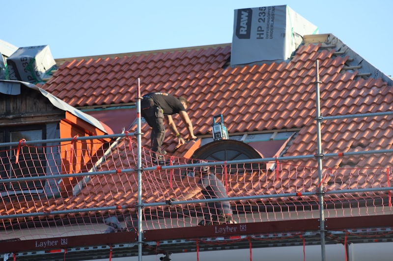 A roofer working on a residential roof during a replacement project.