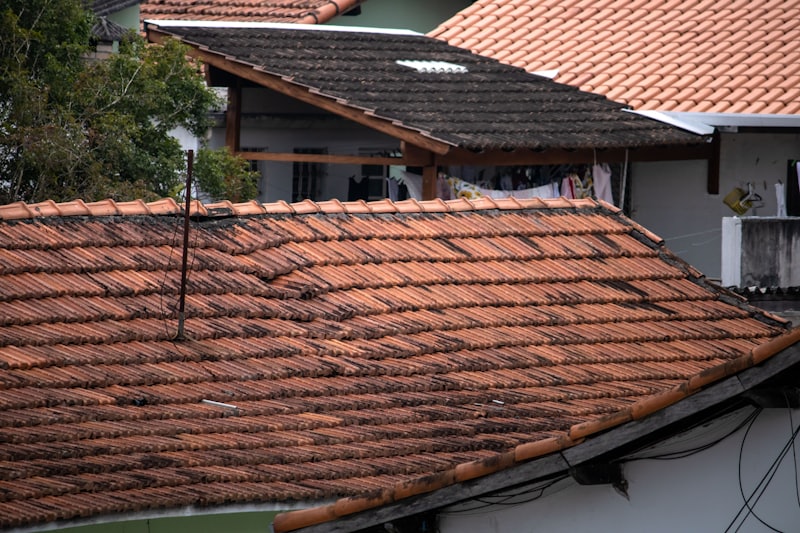 A weathered residential roof with missing and damaged shingles.